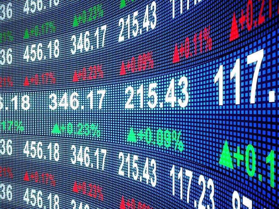 Financial statements and market data laid out on a desk beside a keyboard